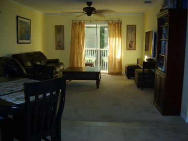 Living room features leather furniture, plasma tv, dvd, and Florida decor.