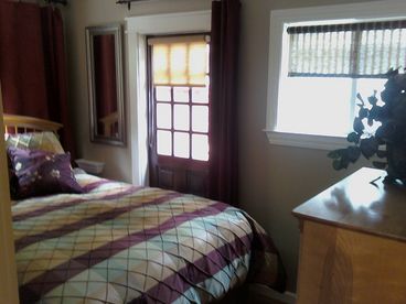 Bedroom 1, a private bedroom has a small closet, 4 drawer chest, and a door to the outside.