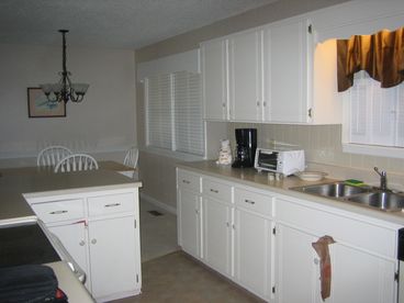 Kitchen with smooth top stove, built in microwave, side by side refrigerator with ice maker, dishwasher, toaster oven,  coffee pot and disposal. Dining table for 6 and bar for 2. 