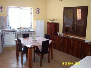 The great living room with the big and comfortable kitchen in artistical ceramic.