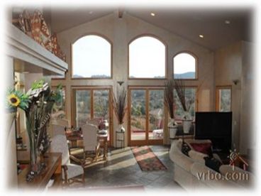 The living room leads onto a deck with 360 degree panoramic views of red rocks.the walls of glass are designed to give you views form every area in the home.The living room has cathedral ceilings and is spacious and enhanced by an abundance of natural sunlight.