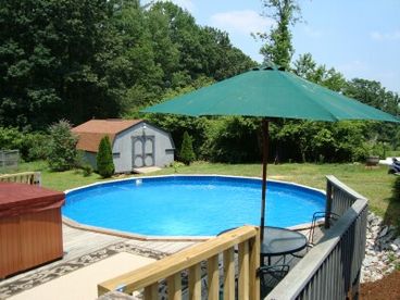 The large back yard has plenty of lawn play area, decks with tables & chairs, large hot tub, above ground pool, and kid\'s playground equipment.