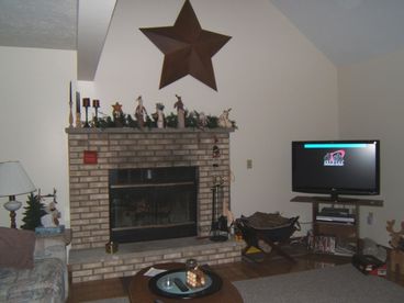 Spacious living room with large screen TV and fireplace