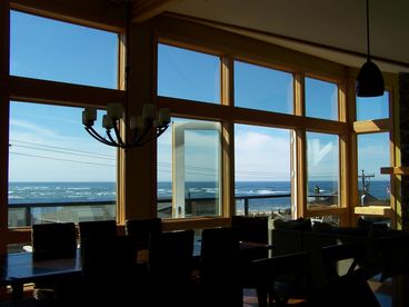 Floor to ceiling windows and french doors give gorgeous views of the ocean and bay. Front deck with chairs.