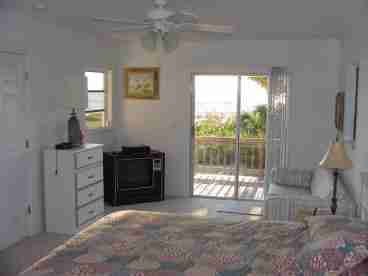 Master bedroom with queen sleeper and TV.  Direct access from the bedroom to the deck and beach