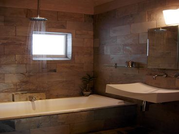 Tiled Bath with Whirlpool Tub and Towel Warmer.