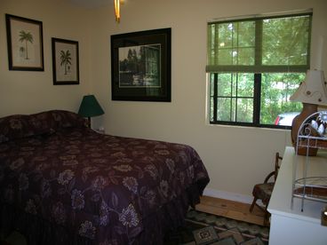 This is the second bedroom, also with a new Queen bed and ceiling fan. It looks onto forested areas on both sides