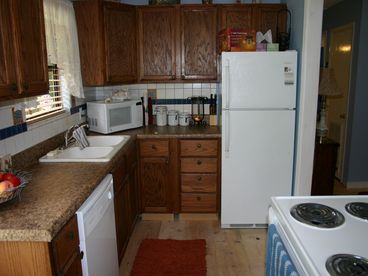 The kitchen features all new cupboards and new appliances. The utility room with new washer/dryer is off this room. The back door leads to patio with grill