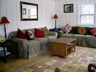Living room with wide open views to Ascutney Mt. Double doors lead out to wrap around deck. View also over 4-hole golf course in summer.
