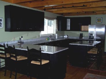 Eat-In Kitchen with Granite counters and stainless steel appliances as well as a large fireplace.