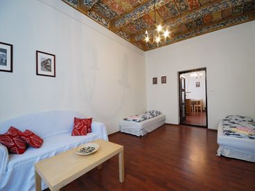 Living room with sofas, single beds, SAT TV and view to the kitchen
