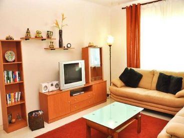 The contemporarily furnished living room is complete with flat screen satellite TV and DVD/CD player.