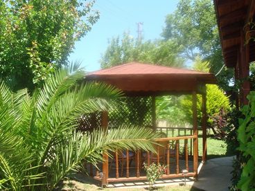 Beautiful summerhouse with table and cushioned chairs