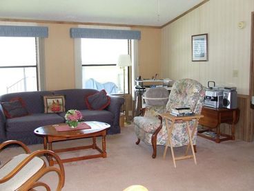 The dining area and living room are open to each other, both featuring large windows, which makes this area bright and sunny.