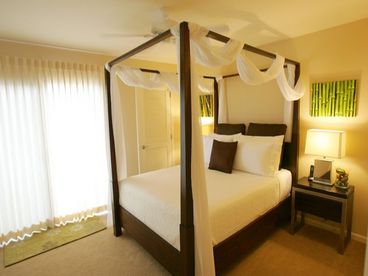 Romantic queen canopy bed in downstairs bedroom.