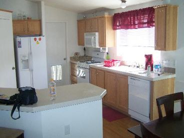 breakfast bar, walk-in pantry, door leads to laundry room. Dishes, silverware, pots, pans and cooking utensils included! Microwave, stove, dishwasher, and refrigerator - all new.