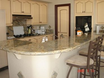 High ceiling wide open kitchen with full walkin food pantry and granite countertop bar