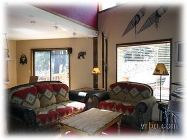 Large open living area facing a wood burning stove, and entertainment center