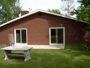 sliding glass doors to the bbq area.  large picnic table and bricked in grill