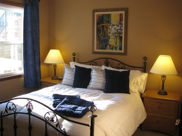 A recently redecorated queen sized bedroom featuring all new luxurious linens and a crisp white duvet.
