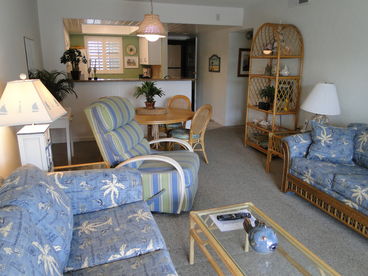 View of Living Room and Dining area from sliding glass door to patio and pool.