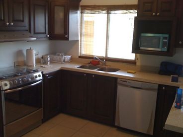 Kitchen includes Dishwasher, Refrigerator, microwave, stove, toaster, blender, dishware and cookware.