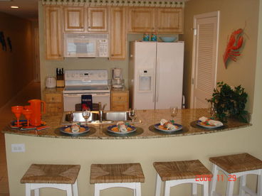 Fully equipped kitchen including a double door refrigerator and a ceramic stove top