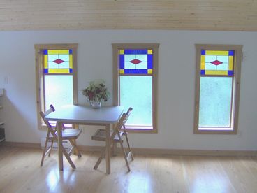 The stained-glass windows are handmade.  Wide plank floors are  throughout the cottage.