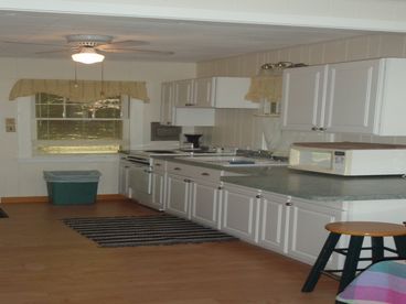 Galley Kitchen with full size kitchen table and chairs to seat 7. Fully stocked with all kitchen dishes, cookware and utensils. 