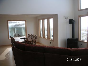 One of the couches next to the gas fireplace and the dining table for 10