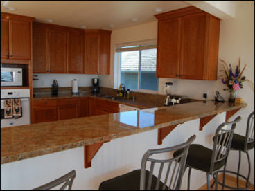Kitchen with granite countertops and bar stools for 4