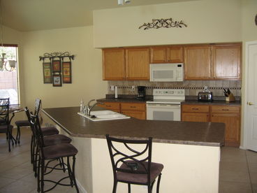 Open Kitchen with new countertops and tile backsplash. 