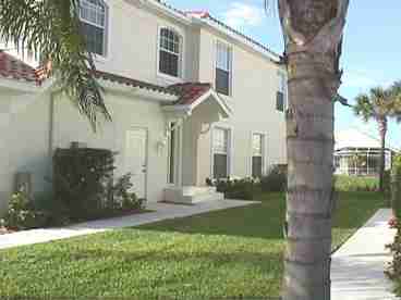 Entrance with windows on three sides of this coach home (entire second floor).  Lots of cross ventilation, light, privacy and security.  Far from the first floor Florida critters!! Garage with side entry.  Home overlooks lagoon with lots of birds, turtles, and fish.  Lanai shading during day with sunsets in the evening.  Across the street from the 14th fairway.