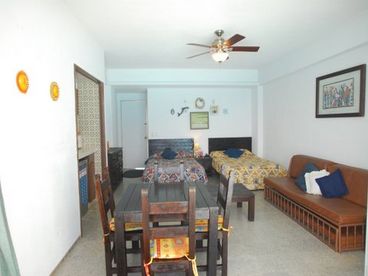Picture of condo looking inside, with table and chairs, and beds.