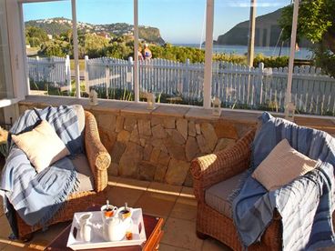 A sunny, covered conservatory with an adjacent plunge pool, offers panoramic views of the Lagoon and Famous Knysna Heads. There is a Weber Gas Grill, a conventional wood-burning braai (barbeque), a gas heater and wooden table with benches and umbrella.
