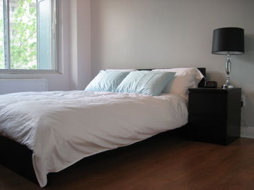Closed large bedroom with a big window. The balcony is accessible from this room as well.