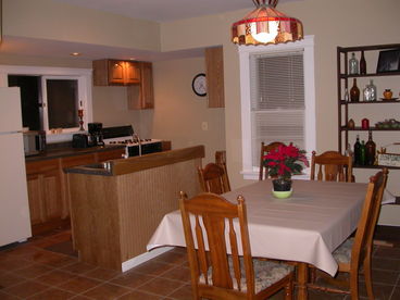 The kitchen and dining area have been combined with a modern island, sink in the middle.  New appliances and the table seats 8.