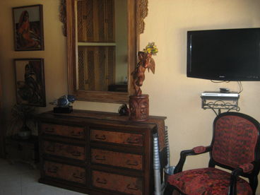 Antique wood carved mirror, with carved angel figurine, add a romantic touch to the bedroom.