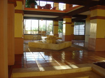 The atrium opens up to a pleasant garden behind the house. Additionally, there is a bar area and living room.