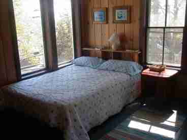 This room is alone up in the turret (3rd floor) it is paneled in knotty pine with a full sized platform bed, dresser, mirror, shelves and best of all windows on four sides and a great view of the bay.