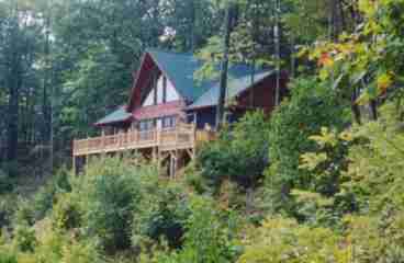 The cabin is nestled under the hardwoods at the top of the ridge.