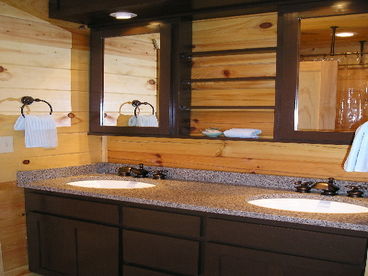 Main level bathroom with double vanity sinks and clawfoot tub/shower.
