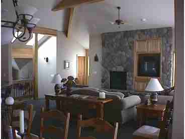 Beautiful vaulted ceiling with exposed beams, skylights, and windows across the back of the room from floor to ceiling.