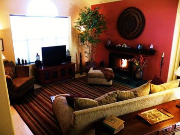 Living Room with gas fireplace, big screen digital LCD cable TV and sound system. Marble floors and ceiling fans. Architectural lighting. Decorated with casual elegance.