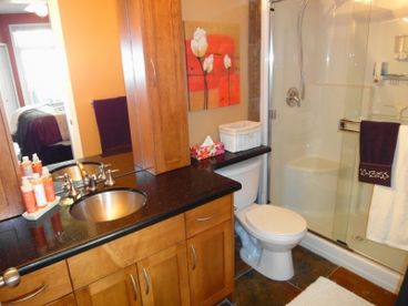 Private ensuite  with glassed shower, granite counters and slate flooring.  