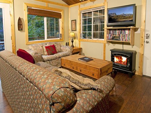 Warm and inviting livingroom with fireplace, flat screen television and river views.