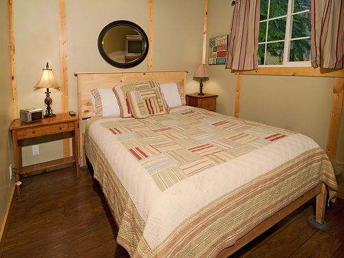 Master bedroom with queen size bed and hardwood floors.