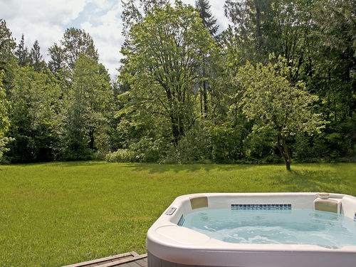 Large back yard by river with hot tub.