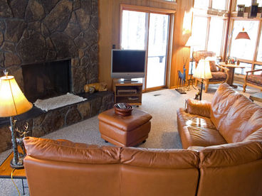 Grand living room with new carpet and lava rock fireplace.  Wall of windows overlooking 16th fairway of the Meadows Golf Course