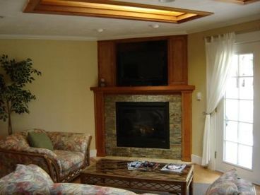 Living Room with cozy fireplace, flat screen TV and french doors opening to deck.